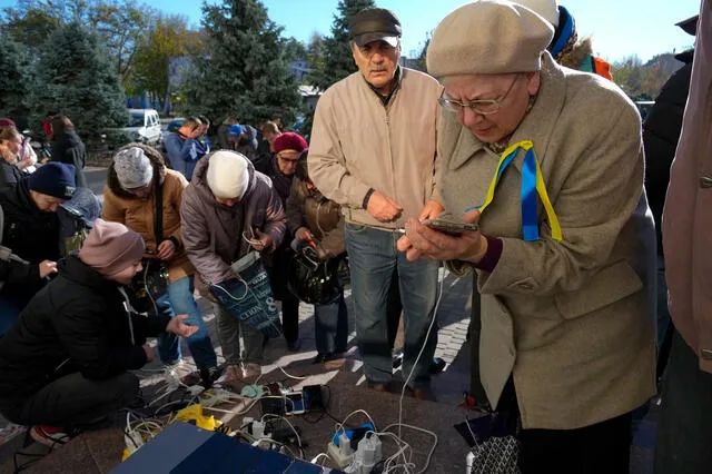 在乌克兰赫尔松的中心广场上，人们正在给手机充电