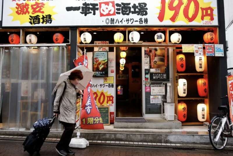 一名日本老人走过廉价居酒屋